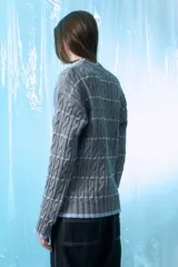 Sweater gris de tejido de ochos con rayas horizontales celestes.