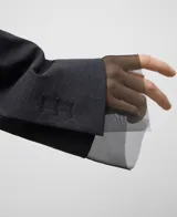 Blazer gris melange de corte holgado con solapa de muesca y cierre frontal de un solo botón. Presenta mangas largas con detalle de organza transparente en los puños y un diseño en la espalda con cruces, drapeados y aberturas. Confeccionado en una mezcla de poliéster y lana merino.