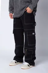 Pantalón cargo negro de corte relaxed fit y tiro medio, con múltiples bolsillos y costuras a contraste en color blanco.