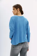 Remera de manga larga color terracota con textura jaspeada, confeccionada en algodón peruano. Presenta un calce holgado con mangas que se ensanchan debajo del brazo y se ajustan en la muñeca.