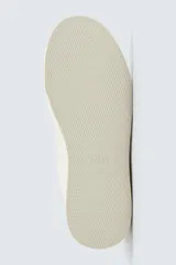 Zapatillas deportivas blancas con detalle de color marrón en el talón y suela con volumen.