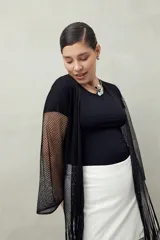 Poncho abierto negro de tejido de red con flecos largos.
