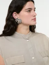 Camisa sin mangas color nude, con botones frontales y dos bolsillos en el pecho.