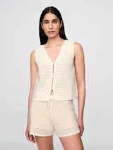 Chaleco tejido al crochet color crema, con escote en V y cierre frontal con botones.