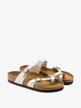 Sandalias Birkenstock modelo Mayari, color blanco aperlado, con dos tiras delgadas ajustables con hebilla metálica y plantilla anatómica de corcho y látex.