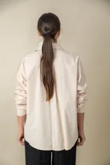 Camisa lisa de manga larga color blanco, con dos bolsillos en el frente y corte holgado.