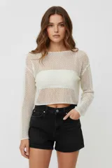 Sweater de punto crochet color crudo, de manga larga, cuello bote y calce holgado, con largo cropped.