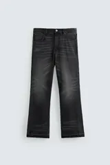 Pantalón de jean negro con efecto lavado, corte flare, cinco bolsillos, cierre frontal con cremallera y botón, y bajo con acabado irregular.