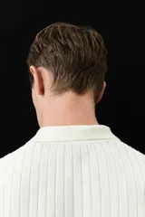 Remera polo de manga corta color crema, en tejido de punto acanalado de mezcla de algodón, con cuello clásico y medio cierre con cremallera.