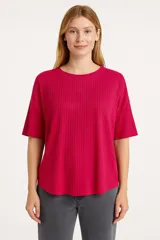 Remera gris de poliéster, de manga corta, corte holgado y cuello redondo.