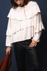 Blusa de lino color blanco, con silueta oversize, cuello bote y volados en el frente.