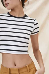 Remera corta blanca con rayas horizontales negras, cuello redondo y mangas cortas.