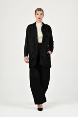 Conjunto de saco y pantalón negro, de diseño holgado y cómodas piezas de ropa.