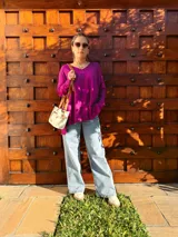 Cartera bandolera de cuero crudo con forro de tela, bolsillo frontal y bolsillo interno. Tiene correa larga regulable y manijas cortas de cuero marrón.