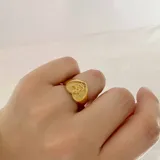 Anillo dorado con forma de corazón y un ángel en el centro, hecho de acero quirúrgico hipoalergénico con baño en oro de 18K.