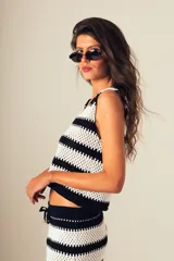 Top tejido a crochet con rayas horizontales blancas y negras, escote en V y cierre frontal con botones.