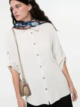 Camisa color marrón claro de lino y viscosa, con cuello clásico, abotonadura frontal y mangas 3/4 con trabillas.