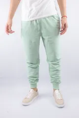 Pantalón jogger color verde claro, con puños en los tobillos y cintura elástica.