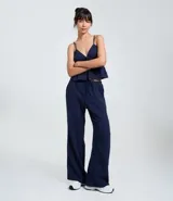 Pantalón femenino azul marino, estilo pijama, confeccionado en algodón texturizado. Posee cintura elástica con cordón para ajuste y bolsillos laterales.