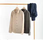 Camisa de lino color beige, con corte ajustado y manga larga, estilo casual y cuello estándar.