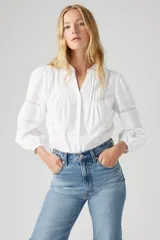 Camisa blanca de mangas largas con detalles de encaje en el frente y en las mangas.