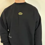 Buzo color beige de corte oversize con estampa en la espalda de botellas de vino y texto en verde.