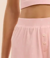 Short de pijama rosado con estampado de corazones, cintura elástica, botones decorativos y volados en el ruedo.