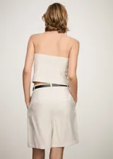 Top strapless blanco con diseño de rayas verticales y cierre de cremallera frontal.