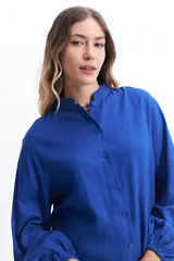 Camisa azul de manga larga con cuello mao y corte holgado.