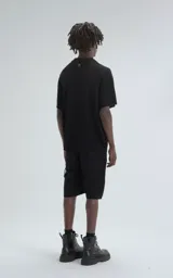 Camisa negra de tejido de punto calado con diseño de zigzag, cuello polo, manga corta y cierre frontal con botones.