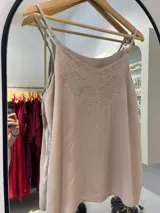 Musculosa color beige rosado con breteles finos ajustables y bordado ornamental en el área del escote.