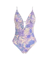 Traje de baño entero con estampado floral en tonos lila, celeste y beige. Tiene breteles finos, escote en V con abertura y espalda baja.