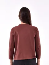 Remera blanca de manga larga con estampa rectangular dorada con diseño animal print y texto 'Fearless, fierce & fabulous'.