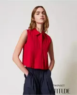Camisa cropped sin mangas de algodón elástico con motivo de pliegues con efecto plisado, cierre con botones en tono a juego y corte recto.