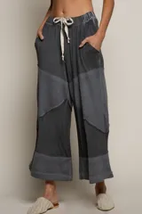 Pantalón palazzo gris con diseño patchwork, cintura elástica con cordón ajustable y bolsillos laterales.