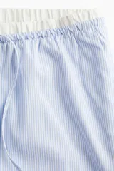 Pantalón de popelina de algodón a rayas celestes y blancas, con cintura elástica, cordón ajustable y bolsillos al bies.