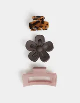 Set de tres broches para el pelo de diferentes formas y colores: uno con diseño carey, otro con forma de flor color marrón y otro rectangular color rosa.