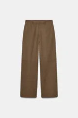 Pantalón marrón de tiro medio con bolsillos delanteros y traseros de parche. Pierna recta y cierre frontal con cremallera, botón interior y gancho.