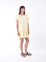 Vestido corto amarillo pastel con mangas cortas con volados y falda con volados.