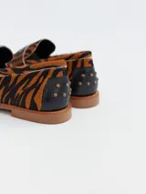 Mocasines con estampado animal print de tigre, confeccionados en cuero.