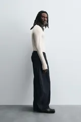 Camiseta de manga larga color crudo, corte ajustado y cuello redondo. Tiene aberturas en los puños y efecto lavado.