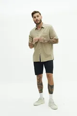 Camisa de manga corta color beige con textura tipo crepé y fit regular.