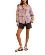 Camisa a cuadros de corte relajado y extragrande, confeccionada en un tejido liviano de algodón. Lleva cuello clásico, cierre frontal con botones y mangas largas con hombros caídos. Los detalles de volantes en los ribetes aportan textura y un toque distintivo, mientras que los puños se ajustan con botón.