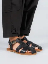 Sandalias bajas doradas con diseño de tiras entrecruzadas y hebilla lateral.