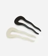 Set de dos pinzas para el pelo tipo pin francés, una de color negro y otra de color crema, hechas de acetato con forma orgánica.