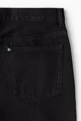 Pantalón de jean negro de corte holgado, con tiro bajo y cinco bolsillos.