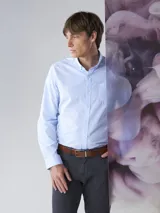 Camisa de botones color celeste con cuello clásico y bolsillo frontal.