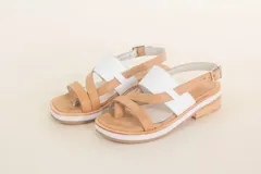 Sandalias de cuero color tostado con tiras cruzadas y detalle de tira ancha blanca en el empeine.