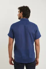 Camisa celeste de manga corta con cuello abotonado y bolsillo en el pecho.