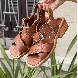 Sandalias negras de cuero con hebilla plateada y taco de madera.